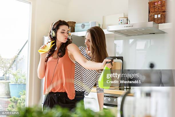 two happy women in kitchen cleaning and listening to music - home cleaning fotografías e imágenes de stock