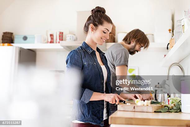 couple in kitchen preparing food - couple kitchen stockfoto's en -beelden