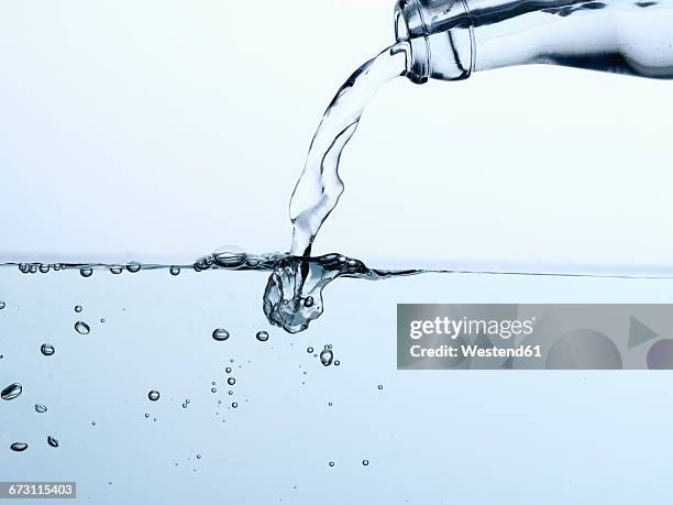 mineral water pouring from bottle - chorro agua fotografías e imágenes de stock