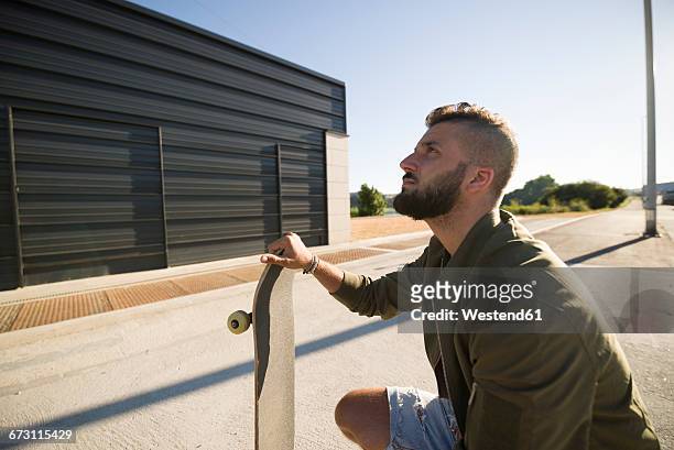 man with skateboard looking up - pompadour imagens e fotografias de stock
