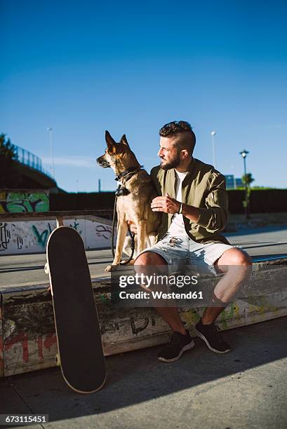 skateboarder with his dog in a skatepark - dog skateboard stock pictures, royalty-free photos & images