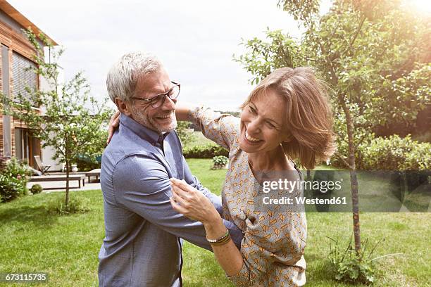 happy mature couple dancing in garden - mature couple stock-fotos und bilder