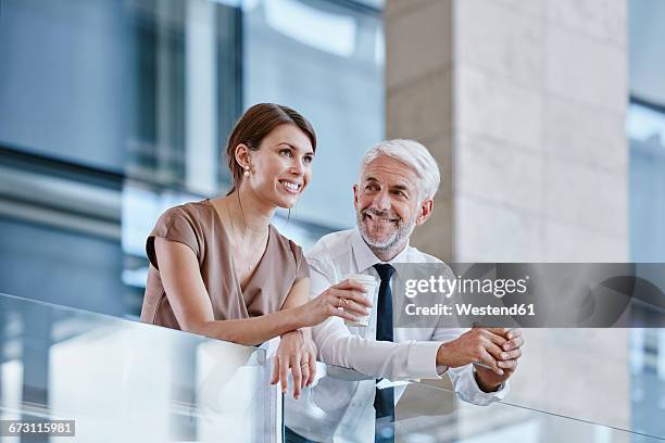 businessman and woman with coffee and cell phone - business recovery stock pictures, royalty-free photos & images