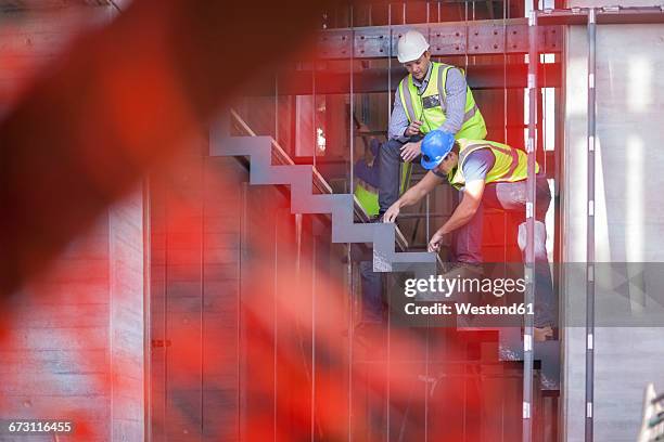 men with reflective vests on construction site - construction site staircase stock pictures, royalty-free photos & images
