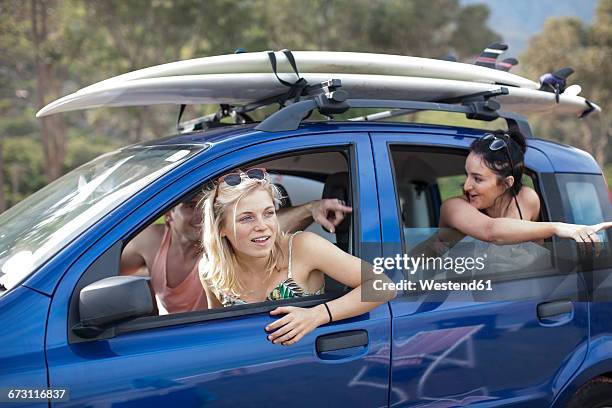 friends omn a trip in car with surfboards on roof - 3 guy friends road trip photos et images de collection