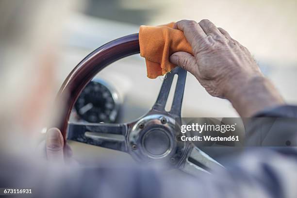 senior man polishing steering wheel of a car - old car stock-fotos und bilder