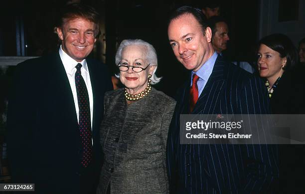 Businessman Donald Trump, standing with two unidentified figures, attends the opening for the new restaurant Daniel, New York, New York, December 16,...