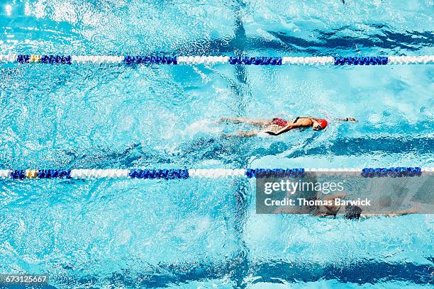 female swimmers swimming in opposite directions - contrast stockfoto's en -beelden