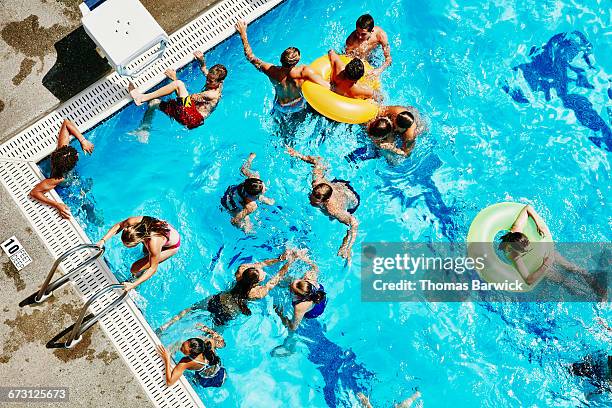 group of friends playing together in outdoor pool - public pool stock pictures, royalty-free photos & images