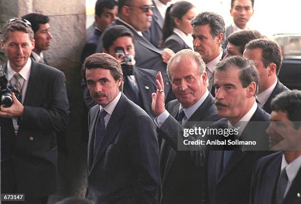 King Juan Carlos of Spain waves as he enters the Swiss Hotel with Spanish President Jose Maria Aznar and Mexican President Vicente Fox November 23,...