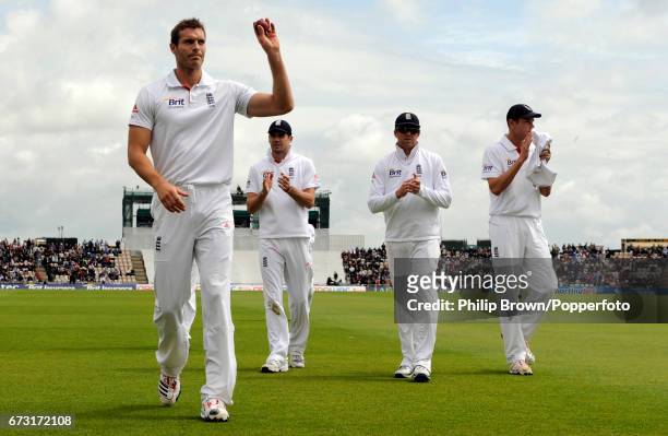 Chris Tremlett of England acknowledges the crowd as he leaves the field after taking six wickets watched by teammates James Anderson , Graeme Swann...