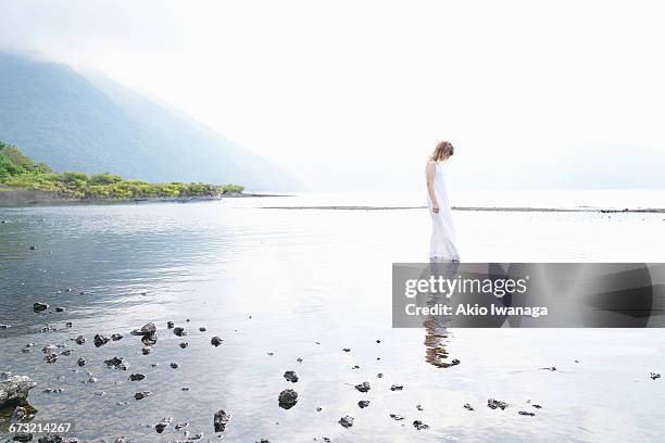 japanese woman standing in lake - women in see through dresses stock-fotos und bilder