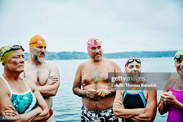 swimmers in discussion before open water swim - standing water fotografías e imágenes de stock