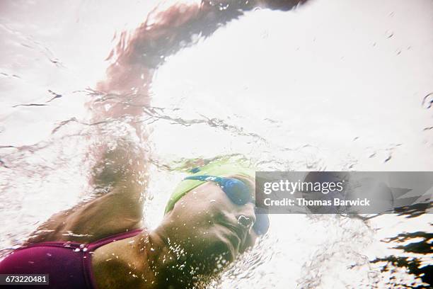 underwater view of mature woman on open water swim - une seule femme d'âge mûr photos et images de collection