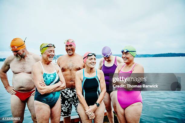 laughing swimmers standing on dock before swim - one piece swimsuit stock pictures, royalty-free photos & images