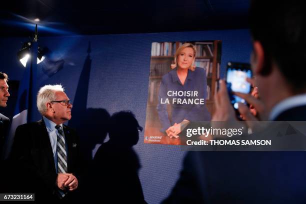 Men look at the French far-right party Front National 's official campaign poster and slogan for the second round of the election during a press...