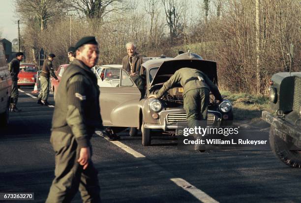 30th January 1972. A motorist looks unconcerned as British soldiers search his car at a roadblock on the Belfast-Londonderry road on the day of a...