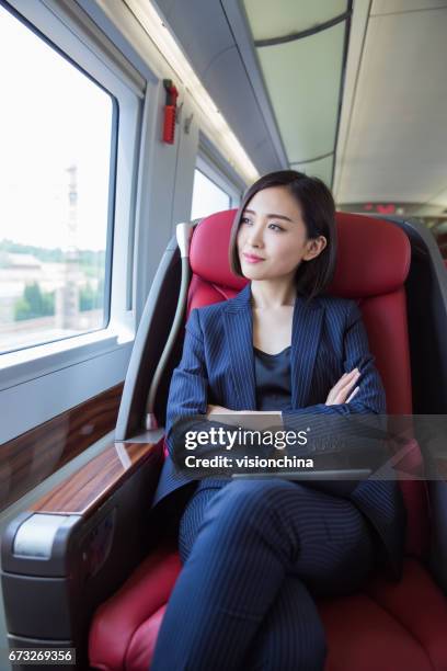 scatto di bella donna d'affari seduta all'interno di un treno ad alta velocità, shanghai, cina. - images of china railway high speed trains foto e immagini stock