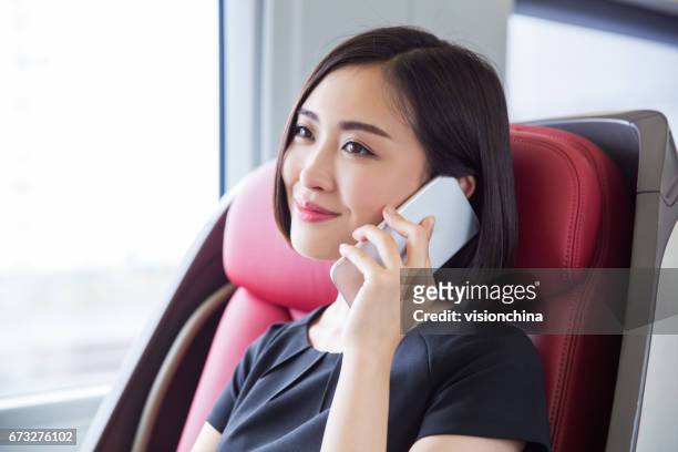 scatto di bella donna d'affari seduta all'interno di un treno ad alta velocità, shanghai, cina. - images of china railway high speed trains foto e immagini stock