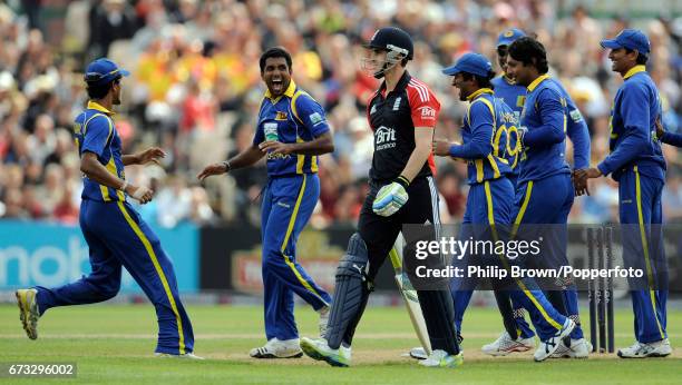 England's Craig Kieswetter leaves the field after being dismissed as Sri Lanka players celebrate during the fifth one-day international cricket match...