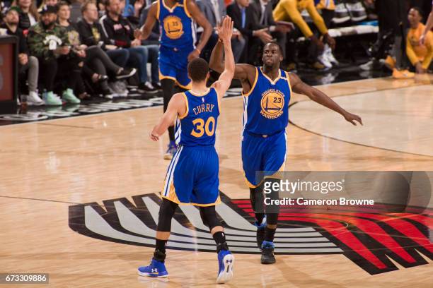 Stephen Curry and Draymond Green of the Golden State Warriors high five against the Portland Trail Blazers in Game Four of the Western Conference...