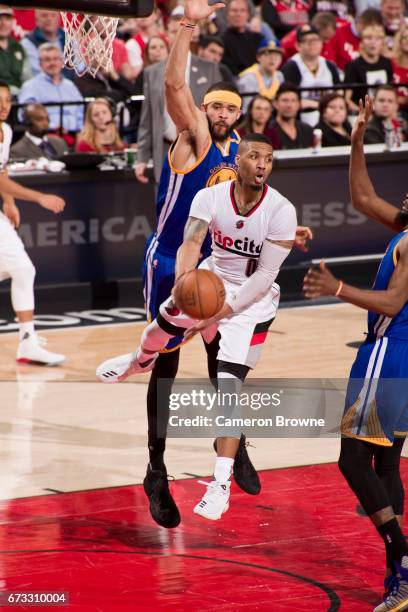 Damian Lillard of the Portland Trail Blazers drives to the basket and passes the ball against the Golden State Warriors in Game Four of the Western...