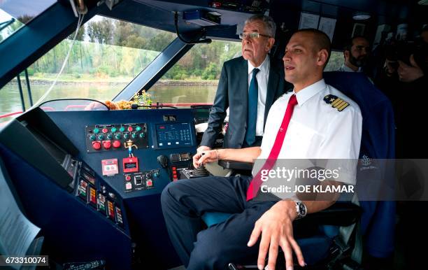 Austrian President Alexander Van der Bellen stands at the captain's bridge onboard the Twin City Liner river ship on the river Danube near...