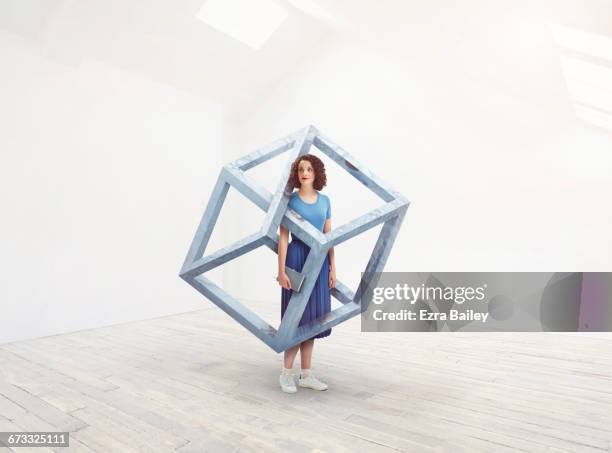 woman interacting with an impossible cube. - silver blouse stock pictures, royalty-free photos & images