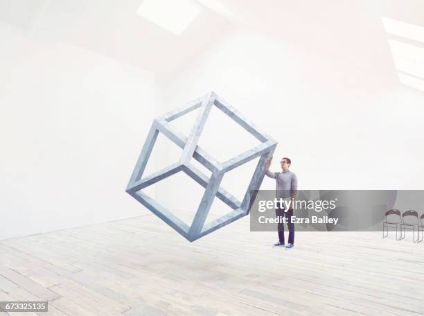 designer being inspired by an impossible cube. - thinking outside the box englische redewendung stock-fotos und bilder