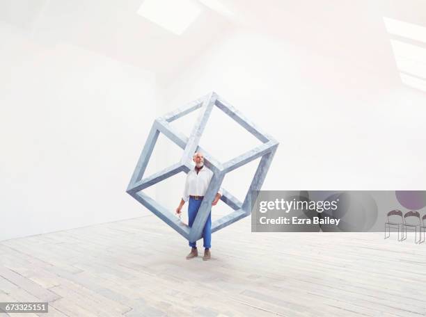 man interacting with an impossible cube. - thinking outside the box englische redewendung stock-fotos und bilder