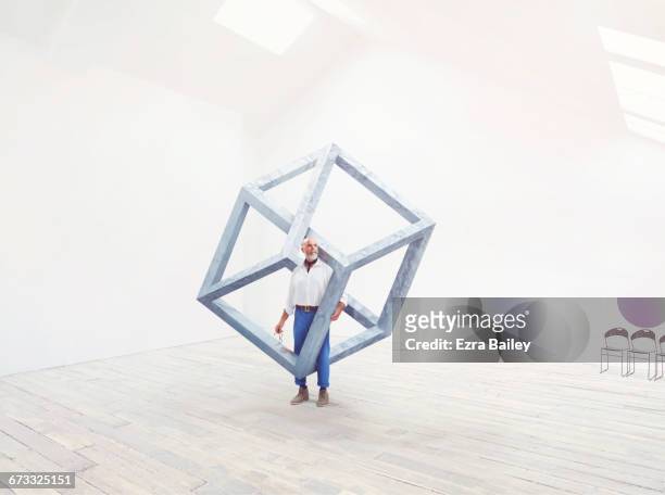 man interacting with an impossible cube. - 3d sculpture stock pictures, royalty-free photos & images