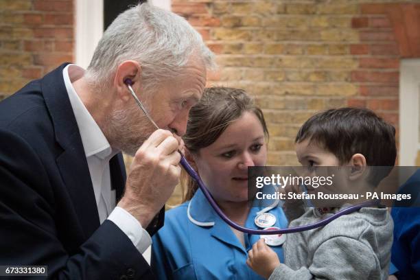 Labour leader Jeremy Corbyn pretends to use a stethoscope with 2-year-old Haroon, after he met NHS nurses, student nurses and midwives to discuss...