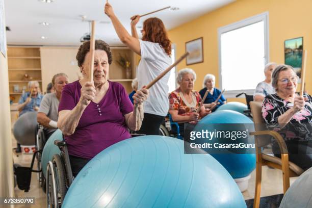 active seniors having physical theraphy in the retirement home - active retirement community stock pictures, royalty-free photos & images