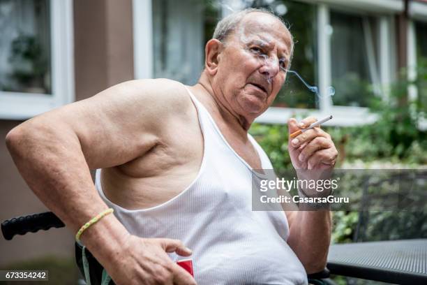 overweight senior man smoking cigarette - smoking issues stock pictures, royalty-free photos & images