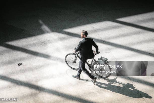 draufsicht auf elegante geschäftsmann mit fahrrad in die stadt gehen - leben in der stadt stock-fotos und bilder
