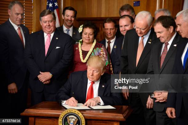 President Donald Trump signs an "Antiquities Executive Order" at the Department of the Interior, on April 26, 2017 in Washington, DC. Interior will...