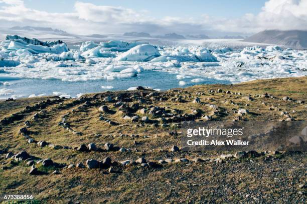 icebergs and stone circle in the jökulsárlón glacial lagoon, south coast of iceland. - stone circle stock pictures, royalty-free photos & images