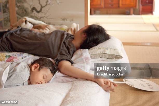 mother and a baby taking a nap - tatami mat stock pictures, royalty-free photos & images