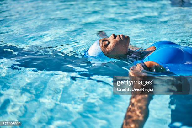 young woman in swimming pool - women by pool stock-fotos und bilder