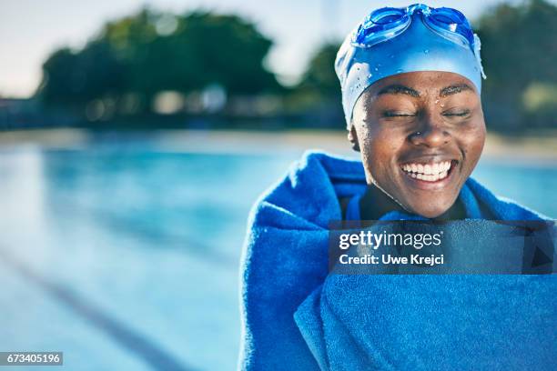 young woman smiling by swimming pool - envuelto en una toalla fotografías e imágenes de stock