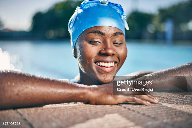 young woman relaxing in swimming pool - cuffia da nuoto foto e immagini stock