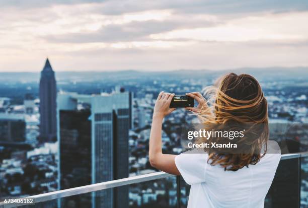 foto de mujer teniendo con el teléfono móvil encima de la ciudad - frankfurt main fotografías e imágenes de stock