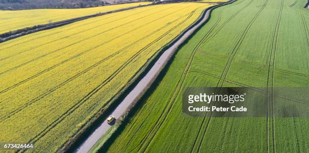 car driving on country road between fields - country road aerial stock pictures, royalty-free photos & images