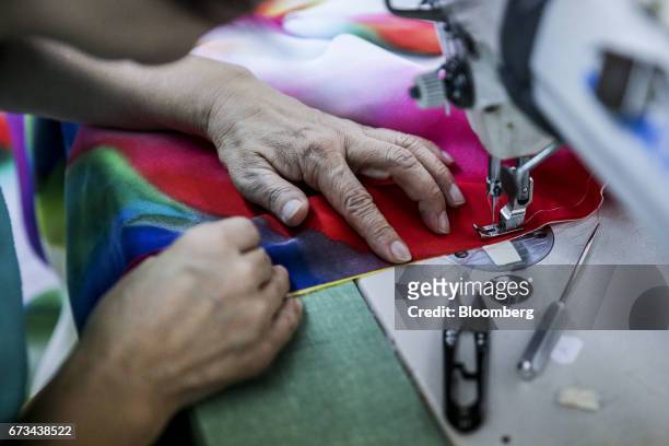 An employee sews fabric at the Ferrara Manufacturing Co. Clothing factory in the Garment District of New York, U.S., on Monday, April 10, 2017....