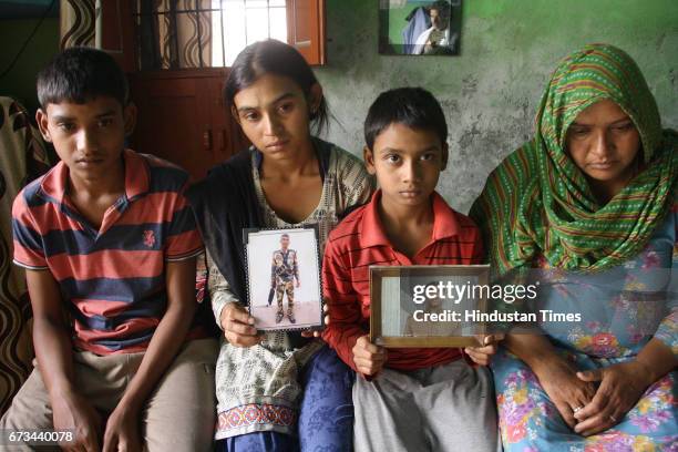 Sonepat martyr Naresh Kumar's wife Rajbala holding his picture along with their three children at Jainpur village on April 26, 2017 in Sonepat,...
