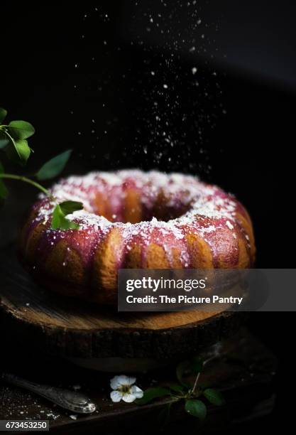 bundt cake with blackberry glaze and white chocolate flakes - chocolate cake texture stock pictures, royalty-free photos & images