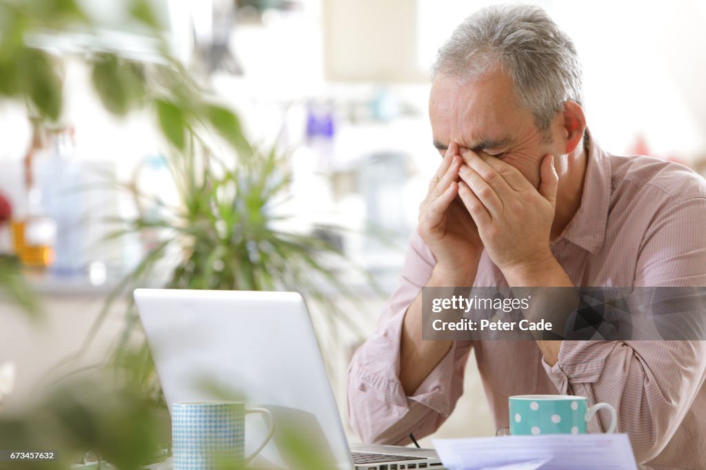 Older man looking stressed with laptop