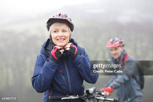 older couple out with bikes on grey day - pushing bike stock pictures, royalty-free photos & images