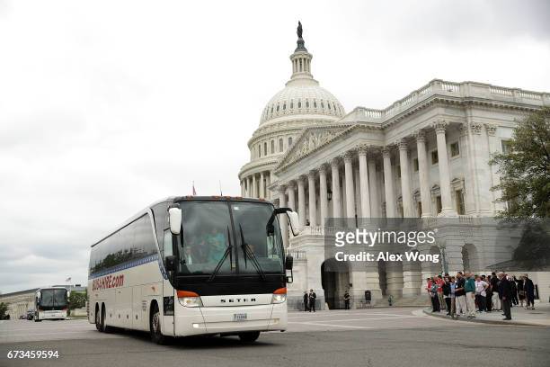 The two buses with Senate members aboard leave the Capitol for the White House April 26, 2017 in Washington, DC. Members of the Senate are attending...