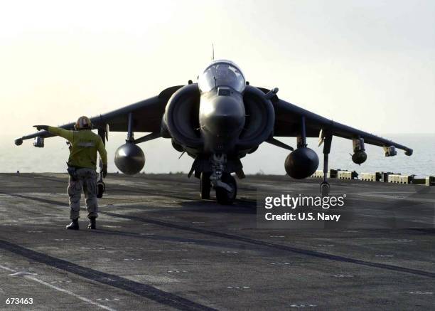 Chief Aviation Boatswain's Mate Harry Stackler directs a returning AV-8B "Harrier" to another handler for directions November 24, 2001 aboard the USS...